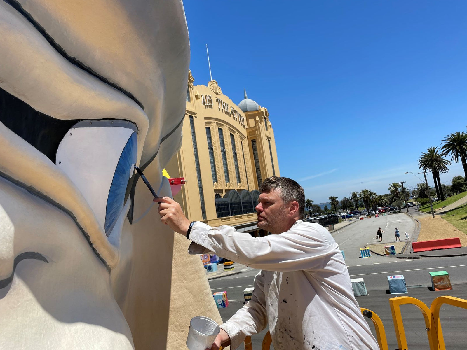 Artist using Viponds paints to restore Luna Park's iconic Mr. Moon sculpture in Melbourne.
